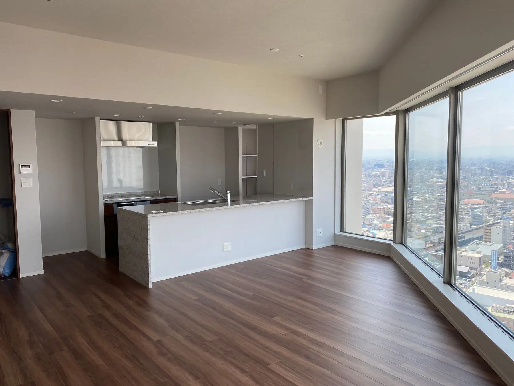 A bright, empty high-rise apartment with a wide city view