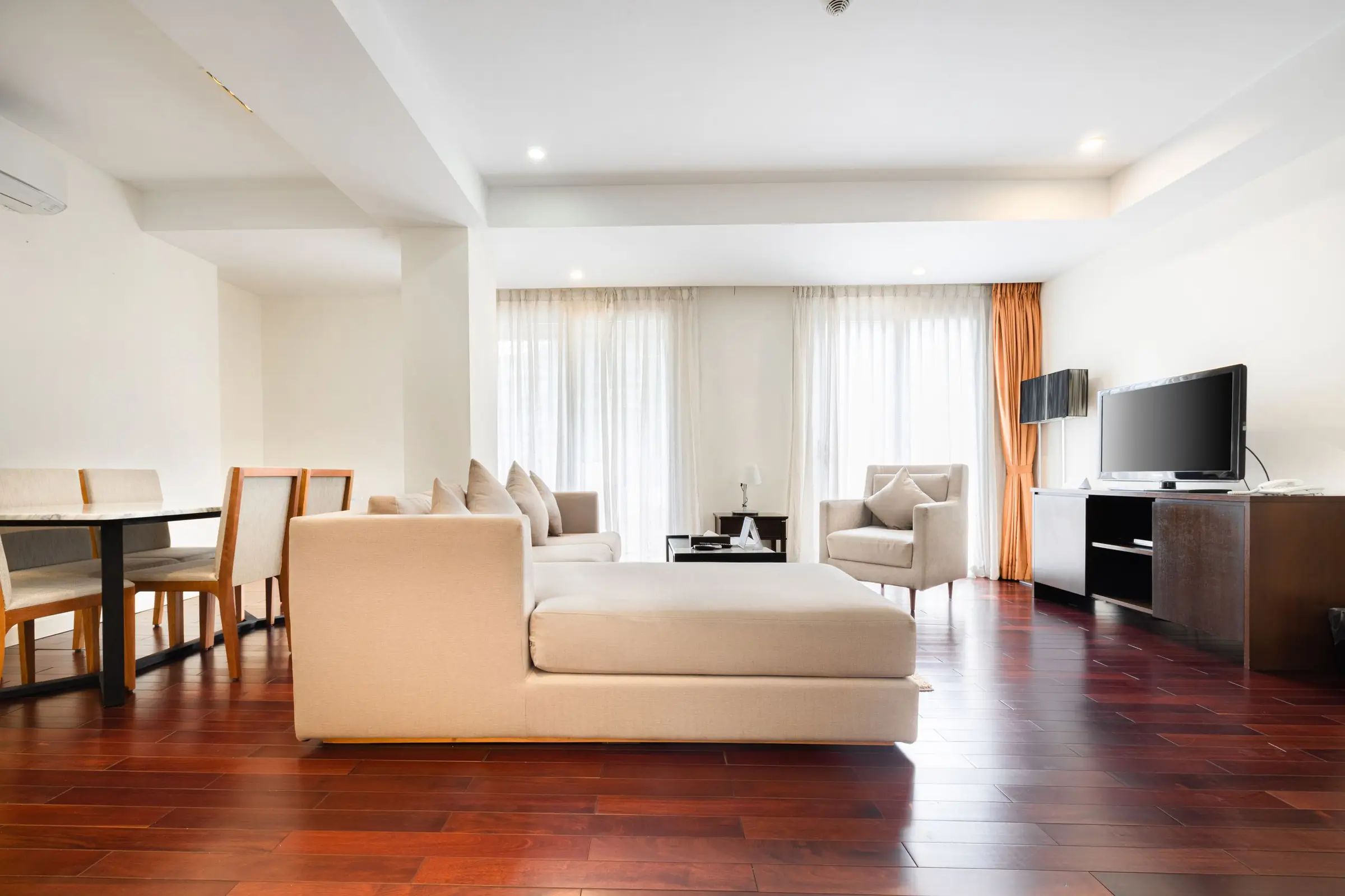 A bright, airy living room with a cream sofa and sheer curtains
