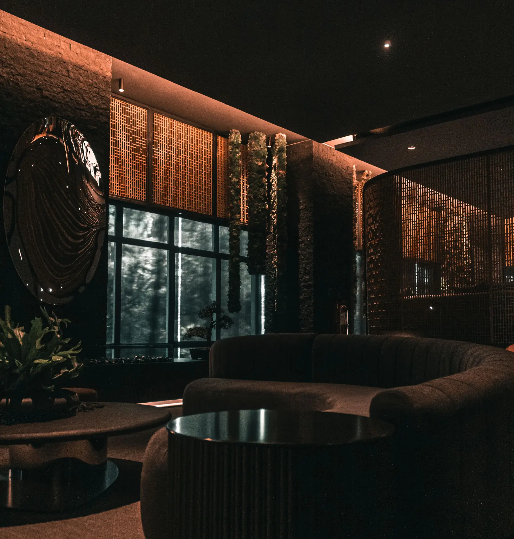 A dimly lit, elegant living room with soft lamps and dark wood